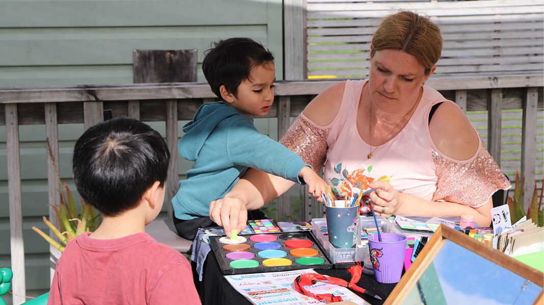 Woman and kids playing with paints